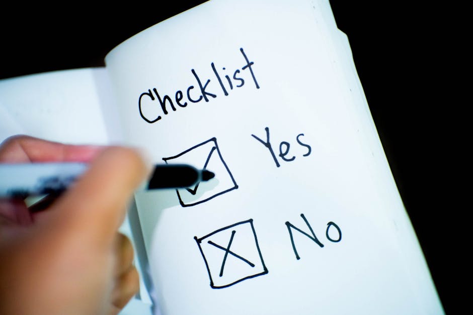 A close-up view of a white sheet of paper featuring a vertical list of five checkboxes, each outlined in black ink; four of these boxes are marked with teal checkmarks, indicating completion or approv
